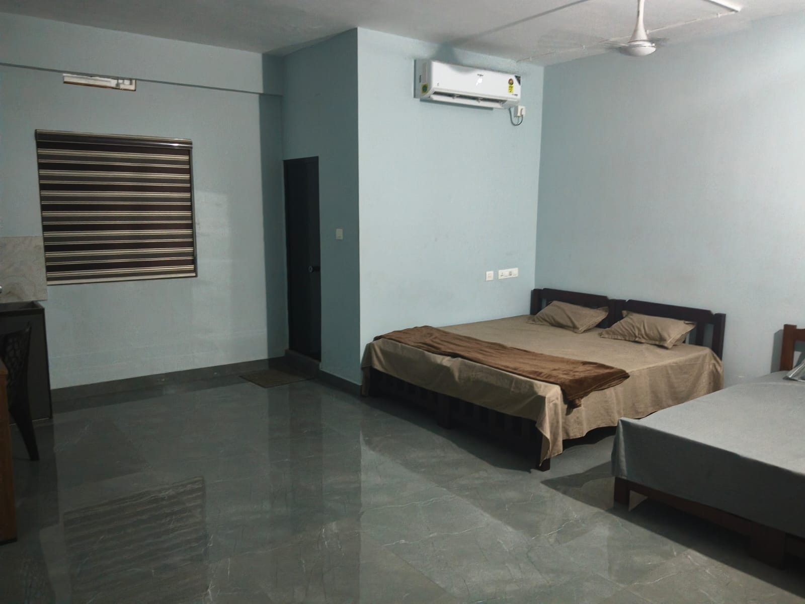Spacious guest room with multiple beds and air conditioning